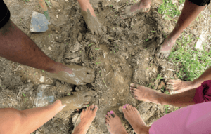 land - Youth program participants at Soul Fire Farm place their bare feet on the soil