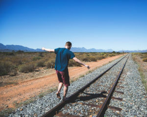 man balancing on train track