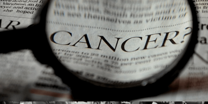 magnifying glass over the word cancer