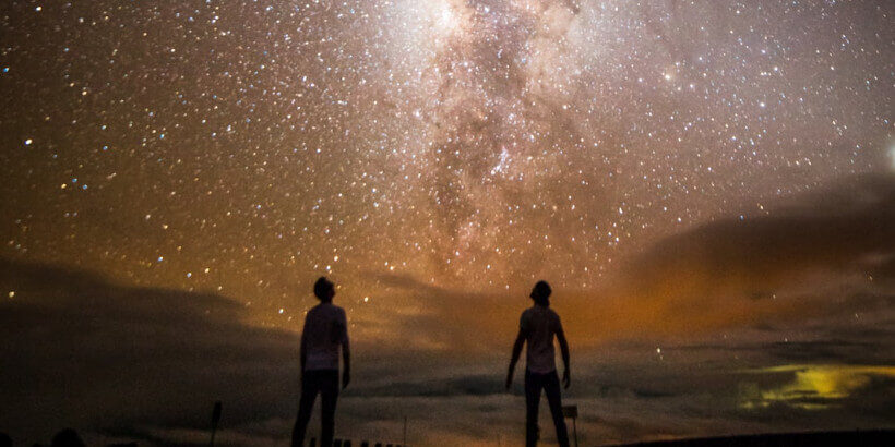 two people looking up at the milky way