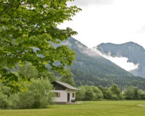 house in meadow next to mountains