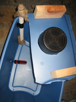 pipe and wood blocks on plastic bin