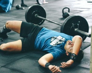 weight-lifter on the ground next to weights